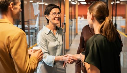Collaborators greeting each other in a corridor